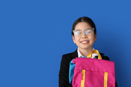 Cute Asian school girl on color backgroundの写真素材