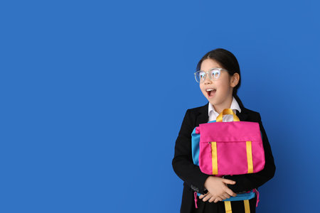 Cute Asian school girl on color background
