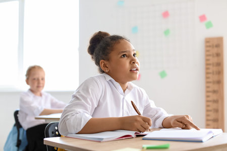 Cute African-American girl during lesson at schoolの写真素材