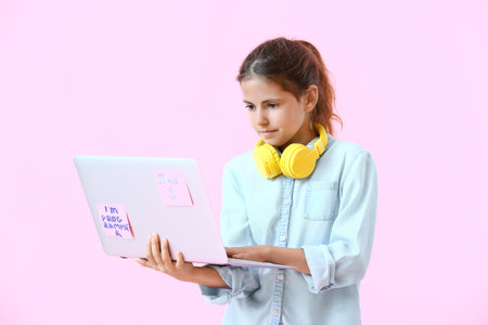 Little programmer using laptop on color background
