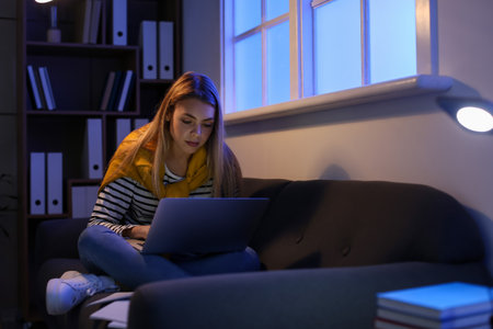 Female student preparing for exam at home late in the eveningの写真素材
