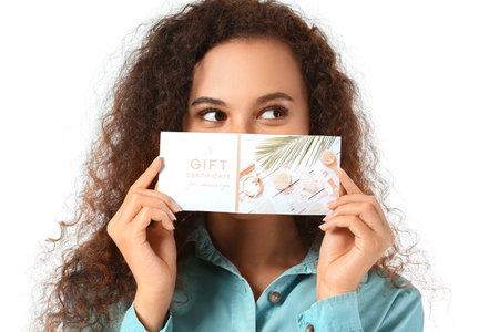 Young African-American woman with gift certificate for massage on white backgroundの写真素材