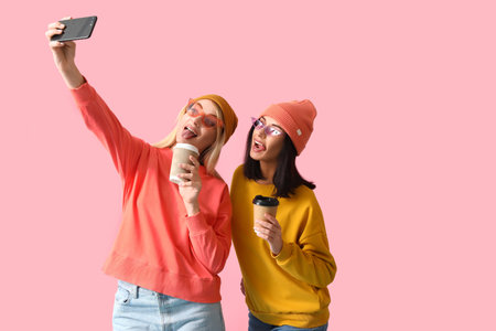 Cool young women taking selfie on color background