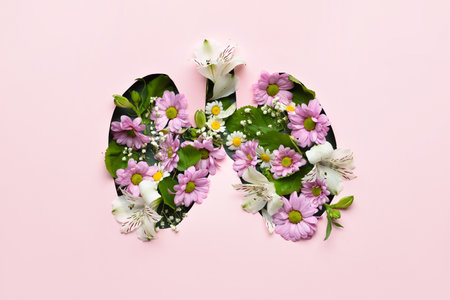 Lungs made of fresh flowers on pink background