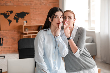 Female colleagues gossiping in office