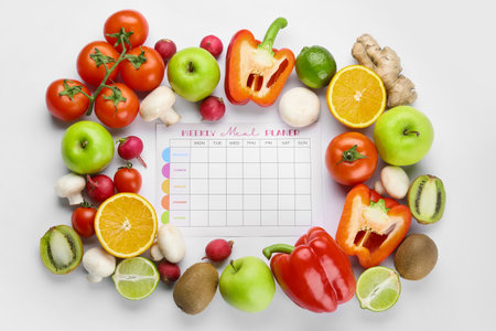 Fruits and vegetables with meal plan on white backgroundの写真素材