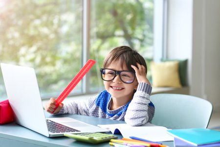 Little boy studying online at home