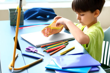 Little boy putting stationery in pencil case at homeの写真素材