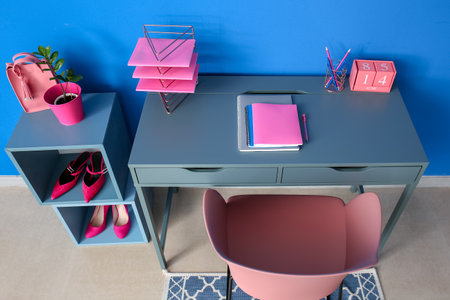 Modern desk with stationery near blue wallの写真素材
