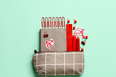 Pencil case and stationery on color background
