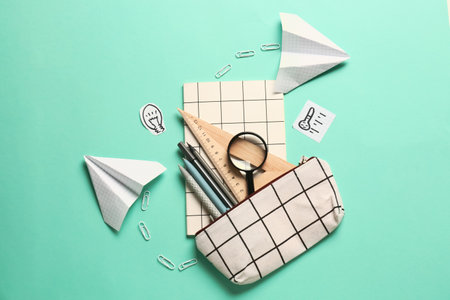 Pencil case and stationery on color background
