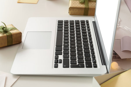 Laptop with Christmas gifts on table in office, closeupの写真素材