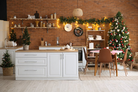 Interior of kitchen with Christmas trees, white counters and dining tableの写真素材