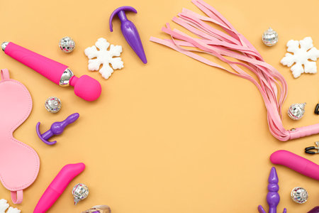 Frame made of sex toys and Christmas decor on yellow background