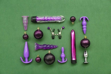 Sex toys and Christmas balls on green background
