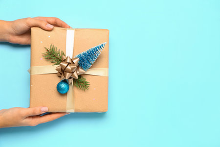 Woman with beautiful Christmas gift on blue backgroundの写真素材
