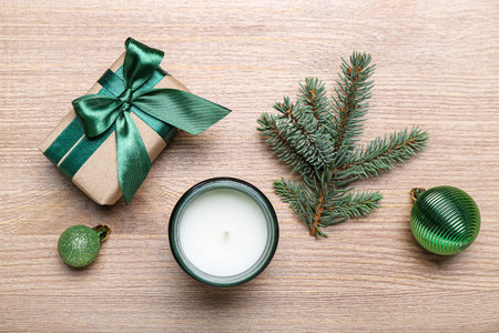 Gift with Christmas branches, balls and candle on wooden backgroundの写真素材