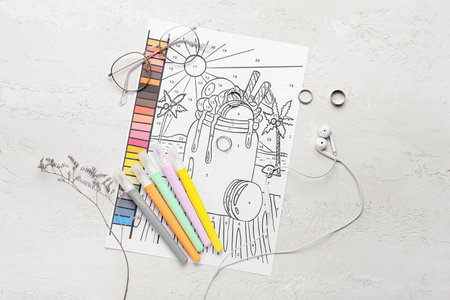Coloring page, felt-tip pens, eyeglasses, earphones and rings on white backgroundの写真素材
