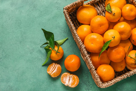 Basket with fresh ripe tangerines on color backgroundの写真素材