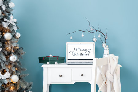 Vase with tree branches, Christmas balls, laptop and gift on table in officeの写真素材