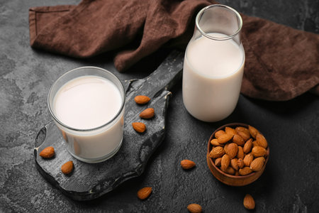 Glass, bottle of almond milk and nuts on dark backgroundの写真素材