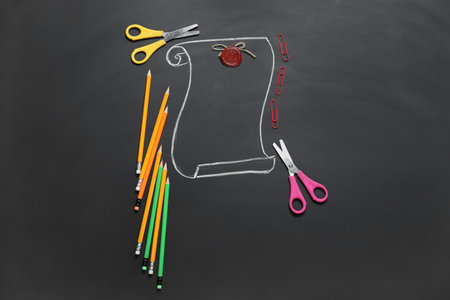 Composition with stationery and drawn vintage scroll on dark backgroundの写真素材