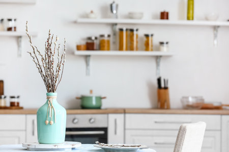 Vase with willow branches on table in dining roomの写真素材