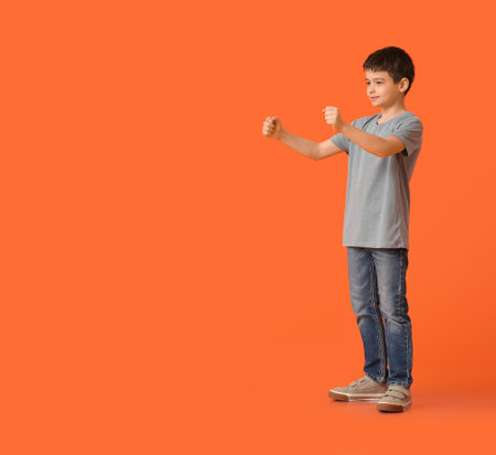 Little boy with imaginary steering wheel on color backgroundの写真素材