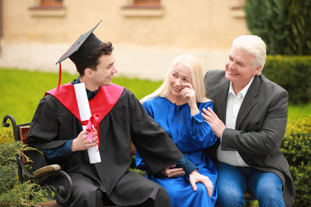 Happy young man with his parents on graduation dayの写真素材