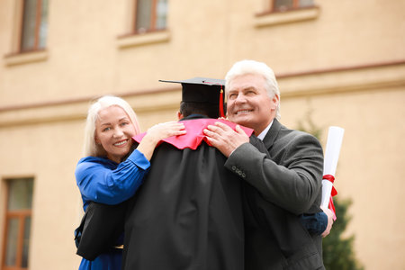 Happy young man with his parents on graduation dayの写真素材