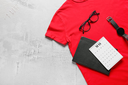 Composition with stylish t-shirt, calendar, notebook and accessories on light backgroundの写真素材