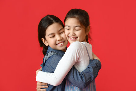 Happy little sisters on color background