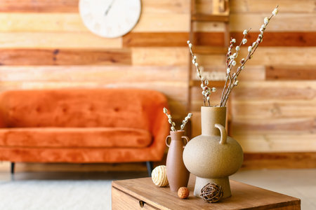 Vases with willow branches on table in roomの写真素材
