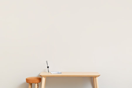 TV stand with reed diffuser and chair near light wallの写真素材
