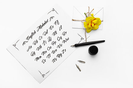 Paper with alphabet, nib pen and envelope on white backgroundの写真素材