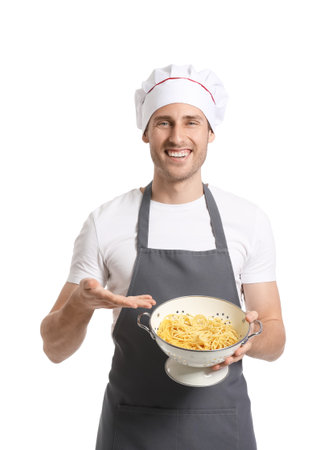 Handsome chef holding colander with spaghetti on white backgroundの写真素材