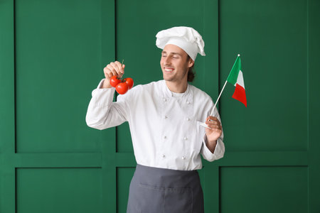Handsome chef with fresh tomatoes and Italian flag on green background