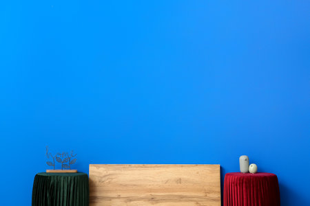 Wooden board with poufs and decor near color wallの写真素材