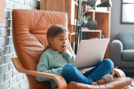 Surprised girl watching cartoons at homeの写真素材