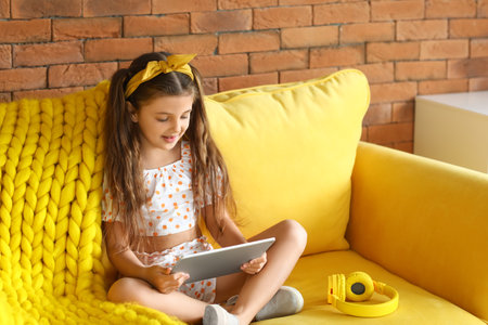Cute girl watching cartoons at homeの写真素材