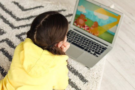 Cute girl watching cartoons at home