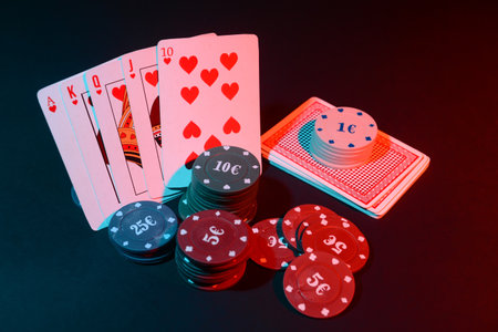 Poker chips and playing cards on dark background