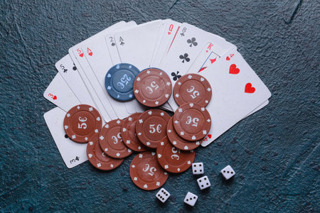 Poker chips, dices and playing cards on dark background