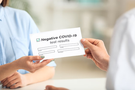 Doctor giving patient her negative covid-19 test result in clinicの写真素材
