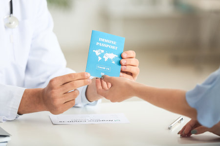 Doctor giving patient her immune passport in clinicの写真素材