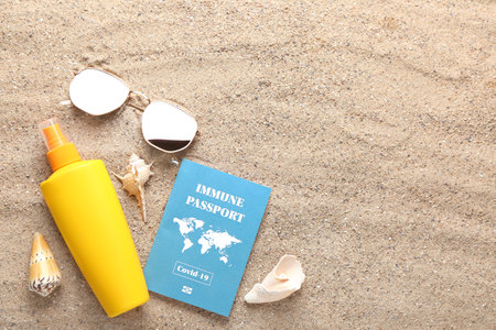 Immune passport, sunglasses and sunscreen on the beach