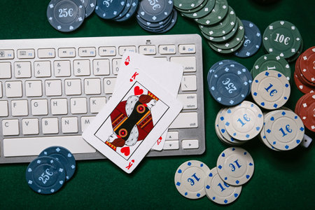 Computer keyboard, playing cards and poker chips on table in casinoの写真素材
