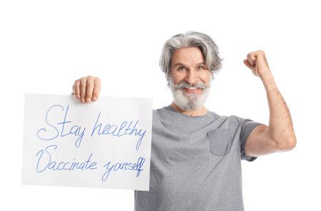 Senior man holding poster with text STAY HEALTHY - VACCINATE YOURSELF on white backgroundの写真素材