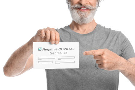 Senior man with negative covid-19 test result on white backgroundの写真素材