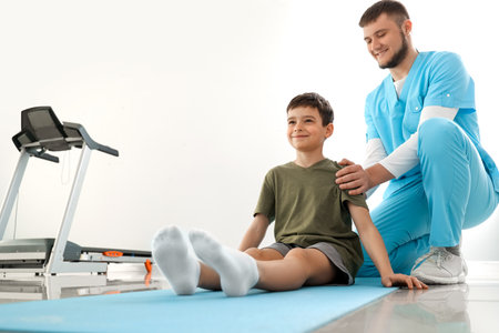Physiotherapist working with boy in rehabilitation centerの写真素材
